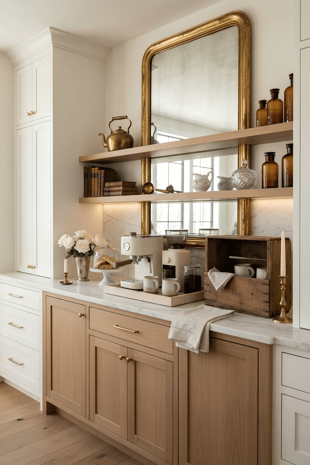 Elegant home coffee bar with a vintage mirror, brass kettle, crystal sugar bowl, old books, and wooden crates.